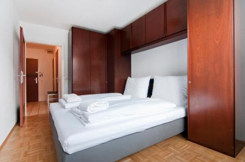 ウィーンにあるTop Location Vienna Marchettiのベッドルーム1室(白いシーツが備わるベッド2台付)