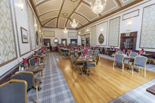 Salutation Hotel في بيرث: مطعم فيه طاولات وكراسي في الغرفة