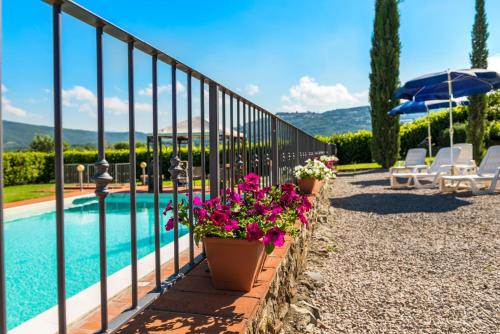 a fence with potted flowers next to a swimming pool at Agriturismo Pian del Vescovo in Massa Marittima