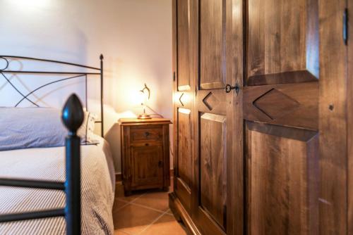 a bedroom with a wooden door next to a bed at Agriturismo Pian del Vescovo in Massa Marittima