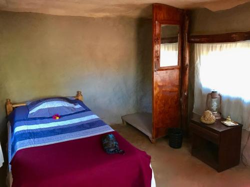 a small bedroom with a bed and a window at Amboseli Eco Camp in Amboseli