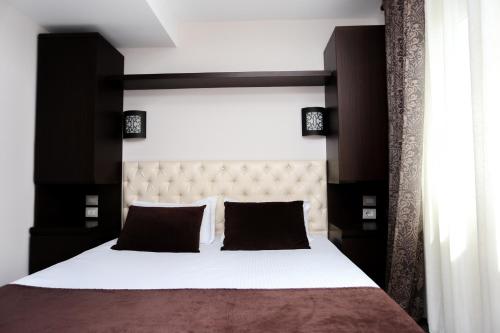 - une chambre avec un grand lit noir et blanc dans l'établissement Hotel Town House, à Tirana