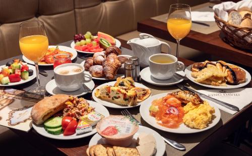 a table topped with plates of breakfast foods and drinks at Kosher Hotel King David Prague in Prague