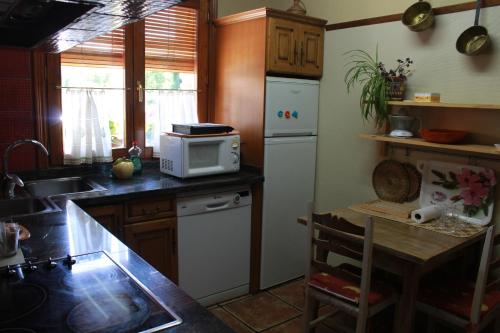 a kitchen with a white refrigerator and a microwave at Casa Rural Edulis in Santurde