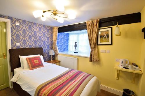 a bedroom with a bed and a window at The Green Dragon in Wellington