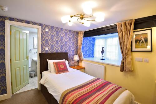 a bedroom with a bed and a window at The Green Dragon in Wellington