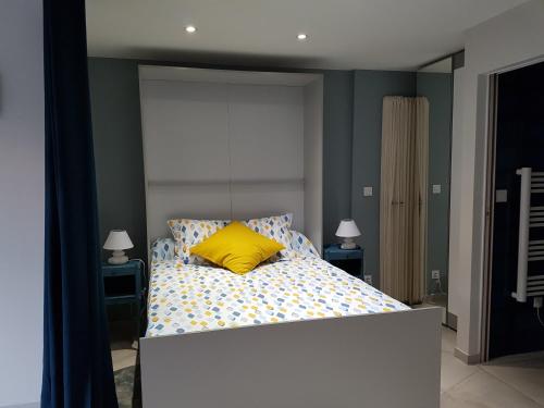 - une chambre avec un lit et un oreiller jaune dans l'établissement Cap Negre villa, à Six-Fours-les-Plages