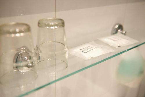 dos vasos claros sentados en una estantería de cristal en Hotel Restaurant de Jonge Heertjes en Aalsmeer
