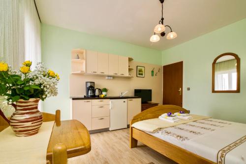 a room with a bed and a table and a kitchen at Pansion Adria in Sveti Filip i Jakov