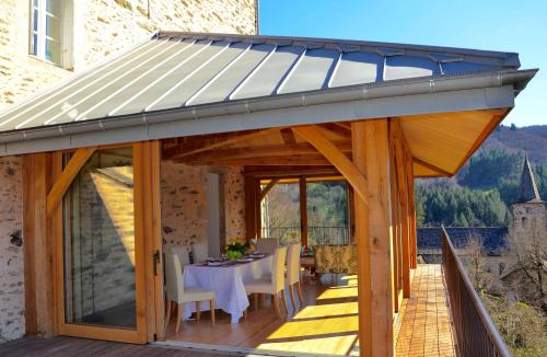 a pavilion with a table and chairs on a deck at Le Couvent in Saint-Just-sur-Viaur
