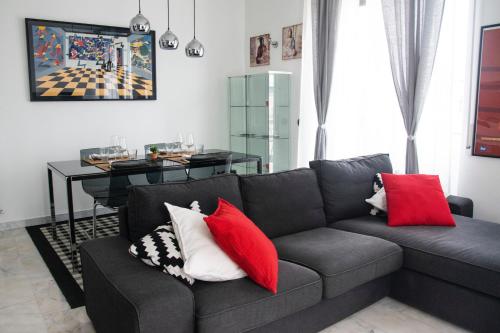 a living room with a gray couch with red pillows at Maison Beaux-Arts in Sanremo