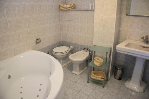 a bathroom with a tub and a toilet and a sink at Maison Beaux-Arts in Sanremo