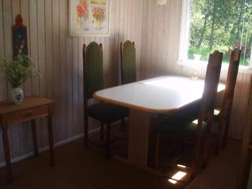 d'une salle à manger avec une table, des chaises et une fenêtre. dans l'établissement Summer cottage, à Nøreng