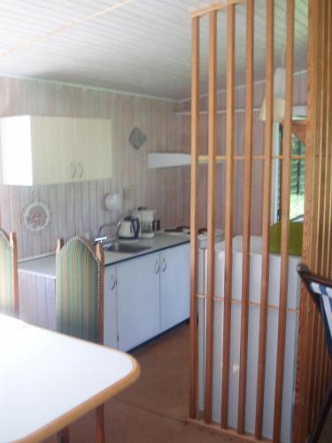 a kitchen with a counter and a table and a table and a kitchen at Summer cottage in Nøreng