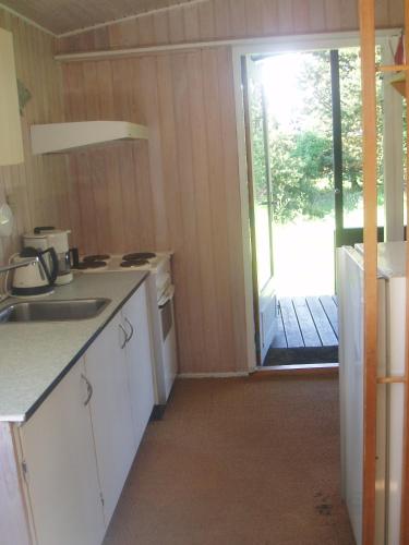 a kitchen with a sink and a door to a yard at Summer cottage in Nøreng