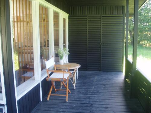 une terrasse couverte avec une table et des chaises. dans l'établissement Summer cottage, à Nøreng