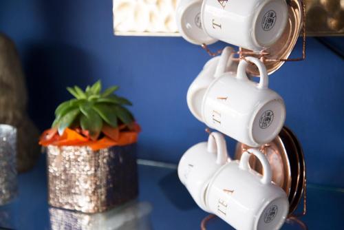 a group of white coffee cups hanging from a wall at Residencial Terra de Mar Calpe, Grupo Terra de Mar, alojamientos con encanto in Calpe