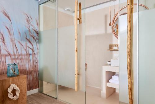 a bathroom with a glass shower stall with a wooden stand at Canal Suites in Kanala