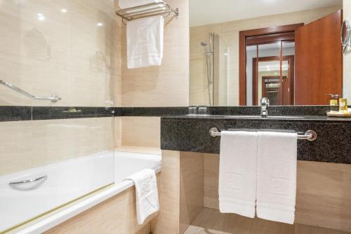 a bathroom with a bath tub and a sink at Eurostars San Lazaro in Santiago de Compostela
