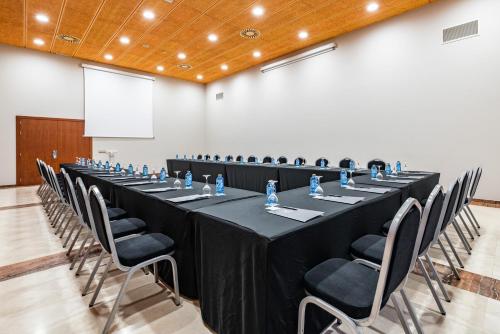a long table in a room with chairs and a screen at Eurostars San Lazaro in Santiago de Compostela