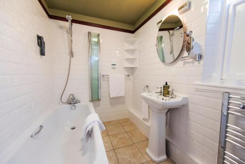 a white bathroom with a tub and a sink at Salutation Hotel in Perth