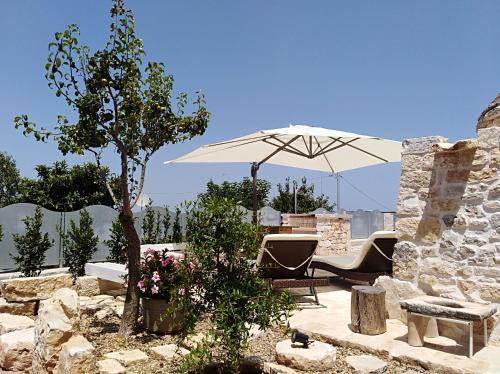 un patio avec une table et un parasol dans l'établissement Dimore Miravalle, à Martina Franca