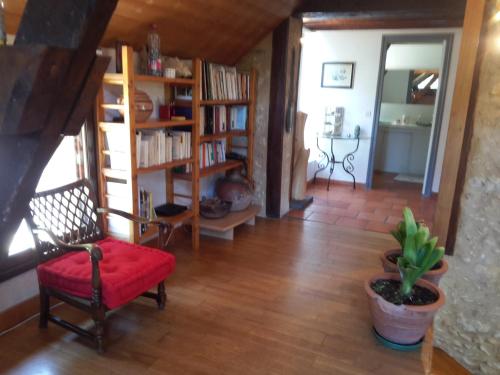 サルラ・ラ・カネダにあるBelle Demeure Sarladaiseのリビングルーム(赤い椅子、本棚付)