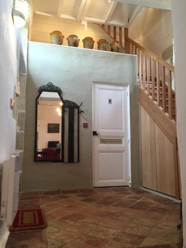 a hallway with a white door and a mirror at Gîte Le Cézan in Jégun