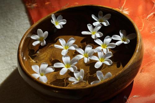 a bowl filled with white flowers on top of water at Crowne Plaza - Dubai Jumeirah by IHG in Dubai