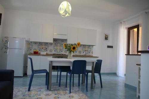 a kitchen with a table with chairs and a vase of flowers at Malvasia - Case Vacanza Il Palmento in Canneto