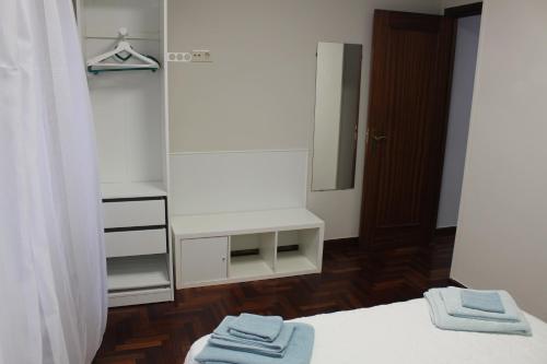 1 dormitorio con espejo y 2 toallas en una cama en En el Corazón de Pontevedra, en Pontevedra