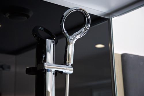 a chrome bathroom sink faucet in front of a mirror at The Z Hotel Tottenham Court Road in London