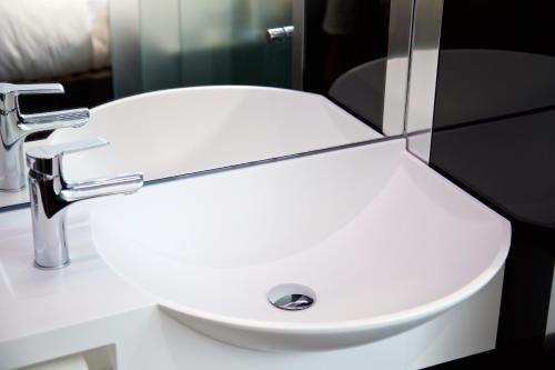 a white sink in a bathroom with a mirror at The Z Hotel Tottenham Court Road in London