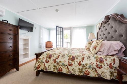 a bedroom with a bed and a dresser at The Elmhurst Inn in Bar Harbor