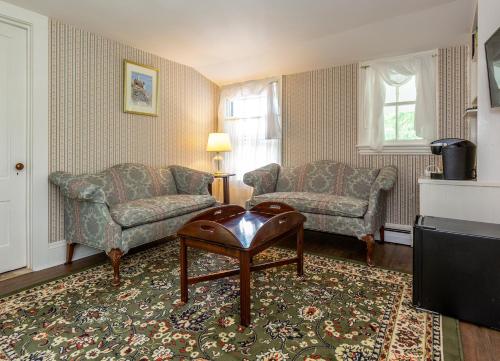 sala de estar con sofá, silla y mesa en The Elmhurst Inn, en Bar Harbor