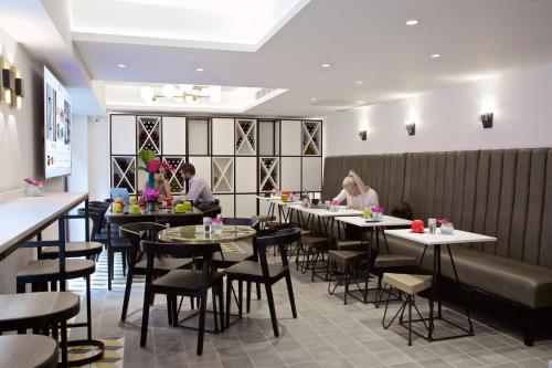 a restaurant with tables and people sitting at them at The Z Hotel Tottenham Court Road in London