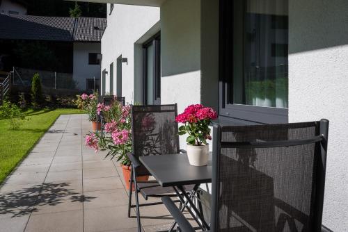 a patio with flowers and a table and chairs at Ferienwohnung Unterlechner in Vomp