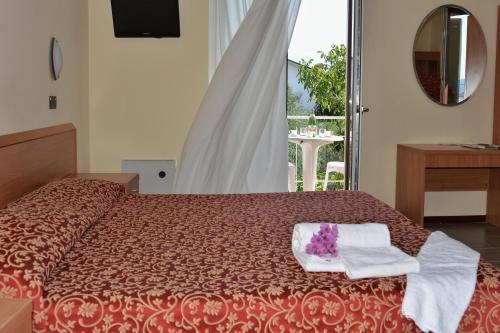 a bedroom with a bed with two towels on it at Hotel Sorriso in Toscolano Maderno