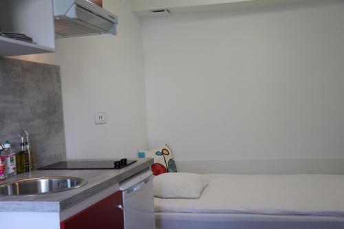 a kitchen with a sink and a counter top at Studio au Coeur du Village avec terrasse et parking proche de Pamiers in Verniolle