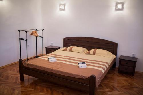 a bed in a room with two nightstands and two at Apartman Nisa in Bihać