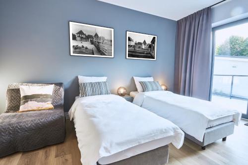 sypialnia z 2 łóżkami i krzesłem w obiekcie Apartamenty Sopot19 w mieście Sopot