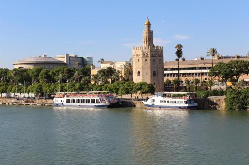 zwei Boote im Wasser vor einem Gebäude in der Unterkunft Resitur Luxury Suit A in Sevilla