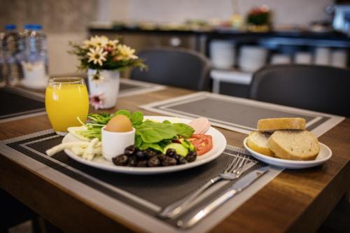 una mesa con un plato de desayuno y un vaso de zumo de naranja en Life Point Hotel, en Trabzon