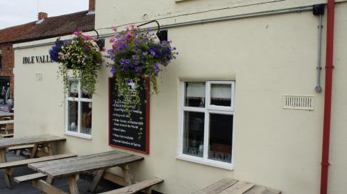 a sign on the side of a building with flowers at Rooms at the Inn in Retford