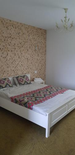 a large white bed in a room with a wall at Fresh Accommodation in Rădăuţi