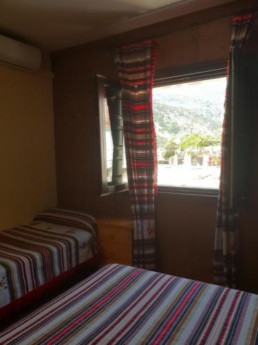 a bedroom with two beds and a window with a view at Hostal Pampaneira in Pampaneira