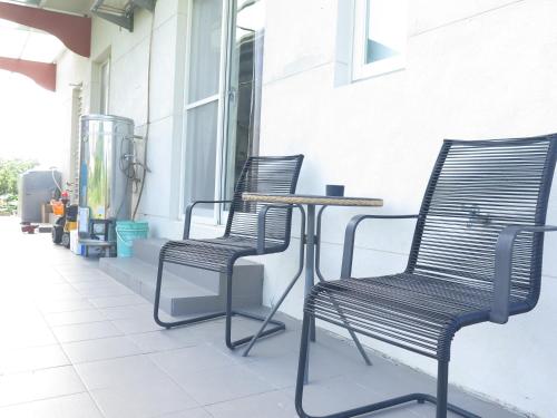 two chairs and a table on a patio at ChaoPingJia Fengge Guesthouse in Wujie