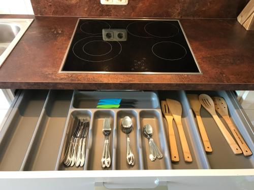 a drawer with silver utensils in a kitchen at Big Dream in Hannover