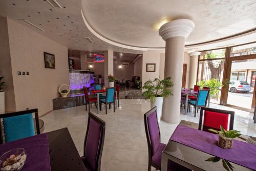 a dining room with purple and blue tables and chairs at Hotel Perfect in Varna City