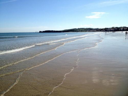 a beach with waves coming in from the ocean at Hôtel Serge Blanco - Relais Thalasso & Spa in Hendaye